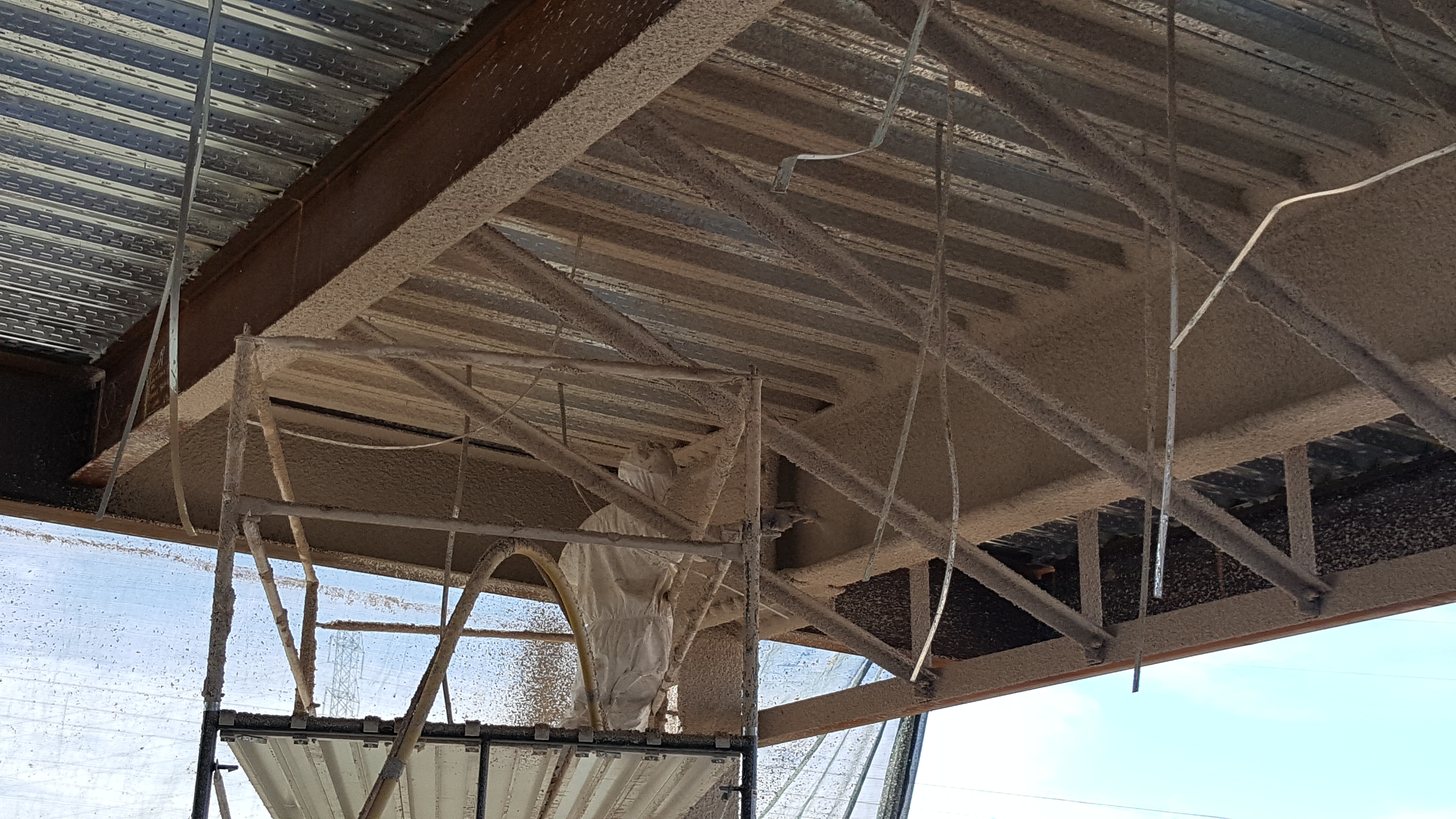 Fireproofed steel beam under deck